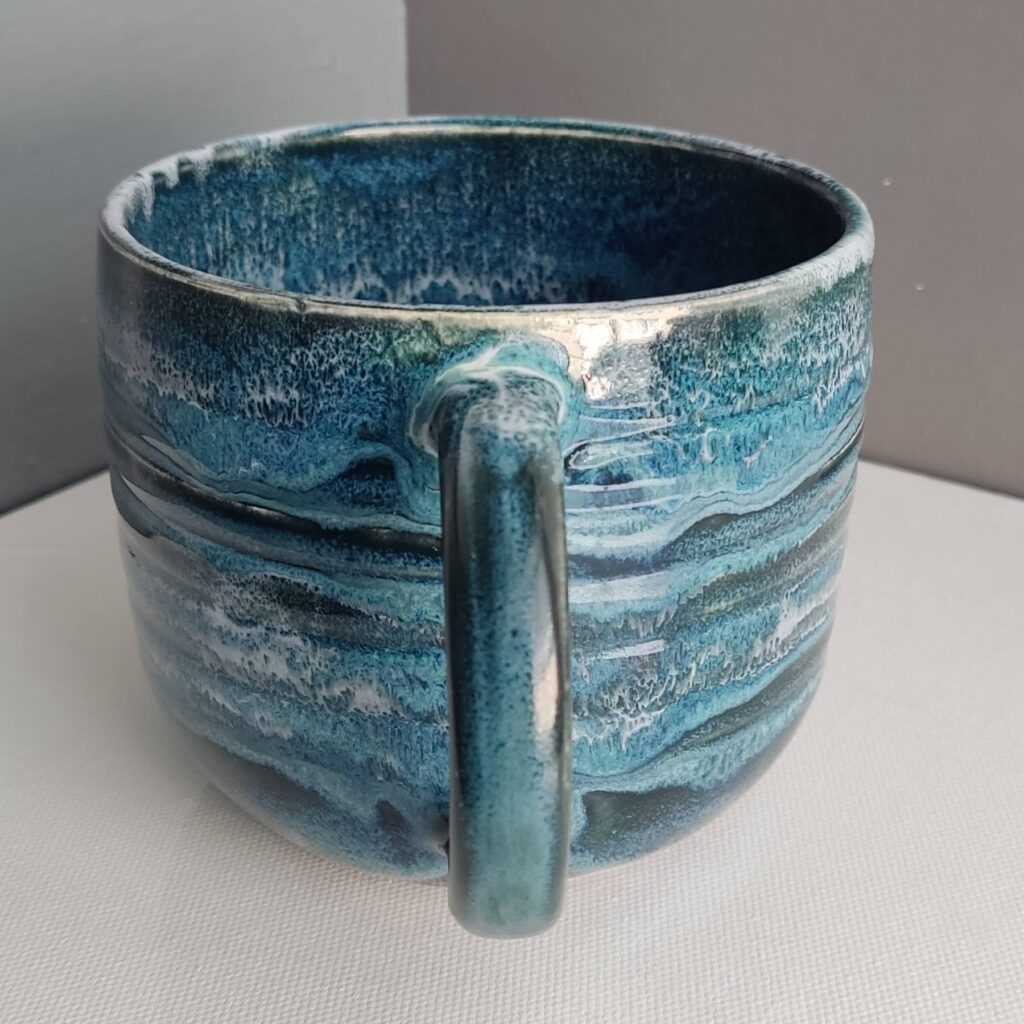 Interior of Snow over Teal Drift over Obsidian glazed mug showing blue glaze surface